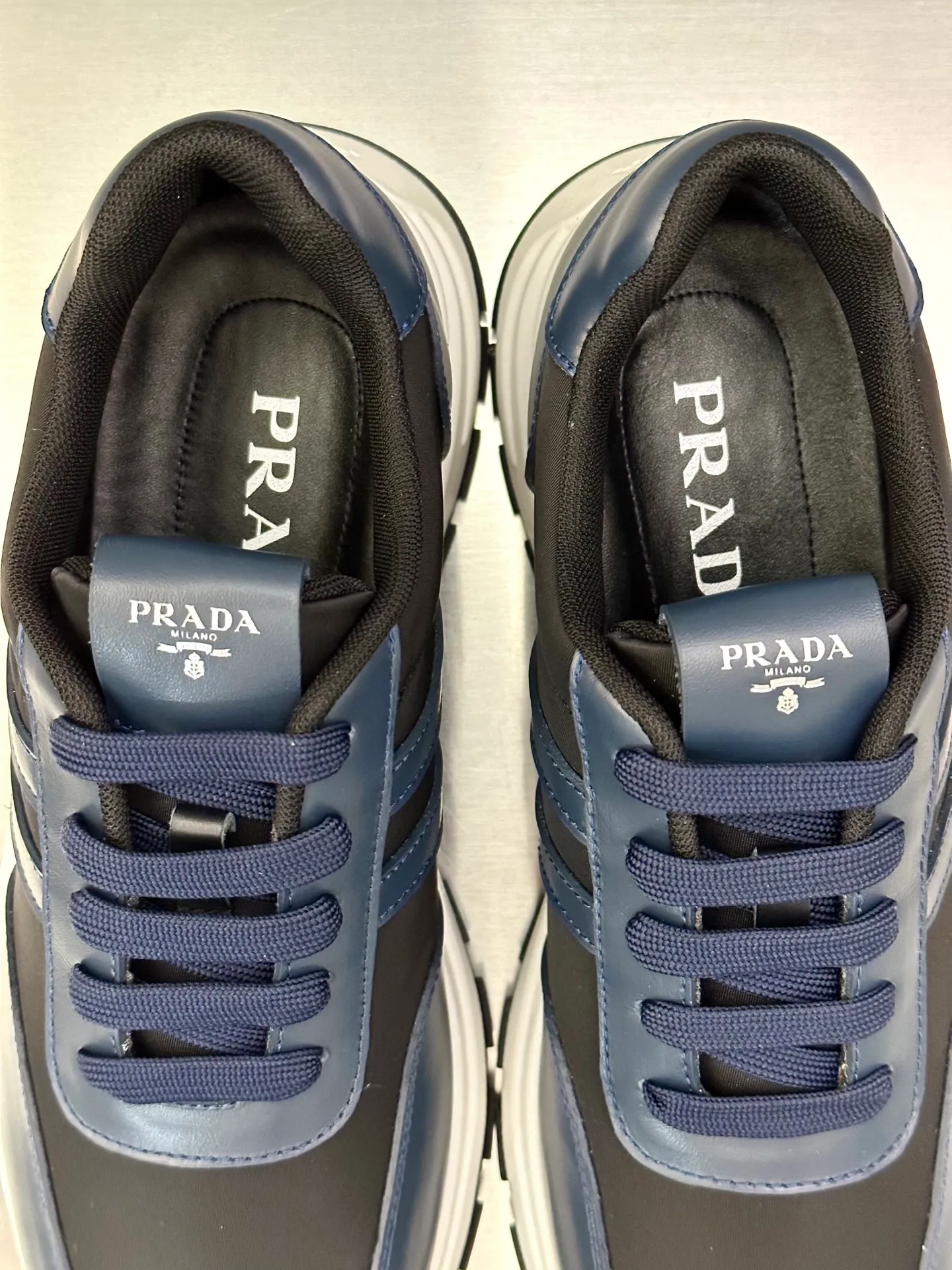 💰740 Prada/Prada men's new mesh stitching sneakers. This sneaker presents a modern version, reinterpreting the brand's archive style with clean lines and smooth details. The shoes are made of calf leather and technical fabric, with a triangular metal logo on the outside, bright TPU decoration on the heel, and a longer and padded inner heel design for a more comfortable fit. The tongue is decorated with a silk-screen logo, and is paired with a hollow rubber sole on the heel. The full cowhide lining comes standard with logo cowhide foot pads, making the upper foot taller, more comfortable, and versatile! Comes with full original packaging! Size: 39-40-41-42-43-44 standard leather shoe size (45 can be customized and does not support returns)